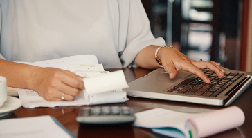 a person working on their laptop and calculator