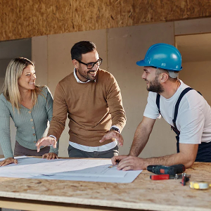 a couple reviewing new home blueprint documents with a homebuilder