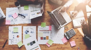 financial documents scattered on a meeting table