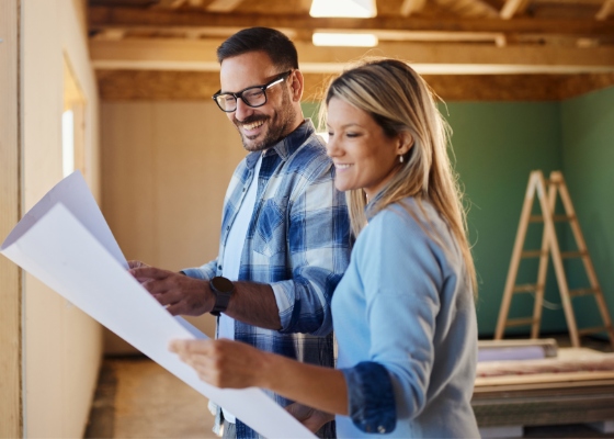 a couple looking at their house blueprints