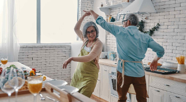 an elderly couple dancing in a kitchen