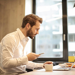 Man in office with a laptop and smartphone