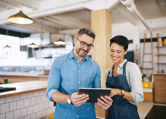 two employees looking at their tablet