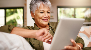 a lady on her couch looking at her tablet