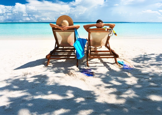 a couple sitting in beach chairs on a beach