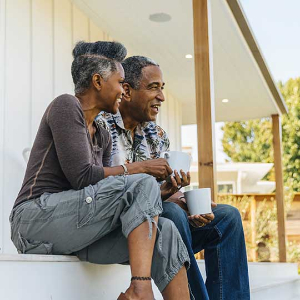 a couple sitting on the steps of their new home