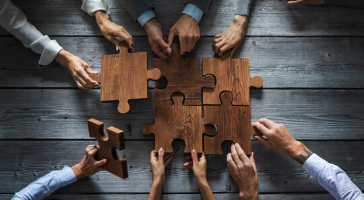 hands putting wooden puzzles together